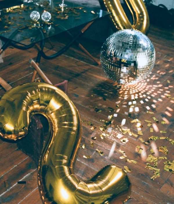 The aftermath of a party, with glitter on the floor and empty wine glasses on the coffee table.